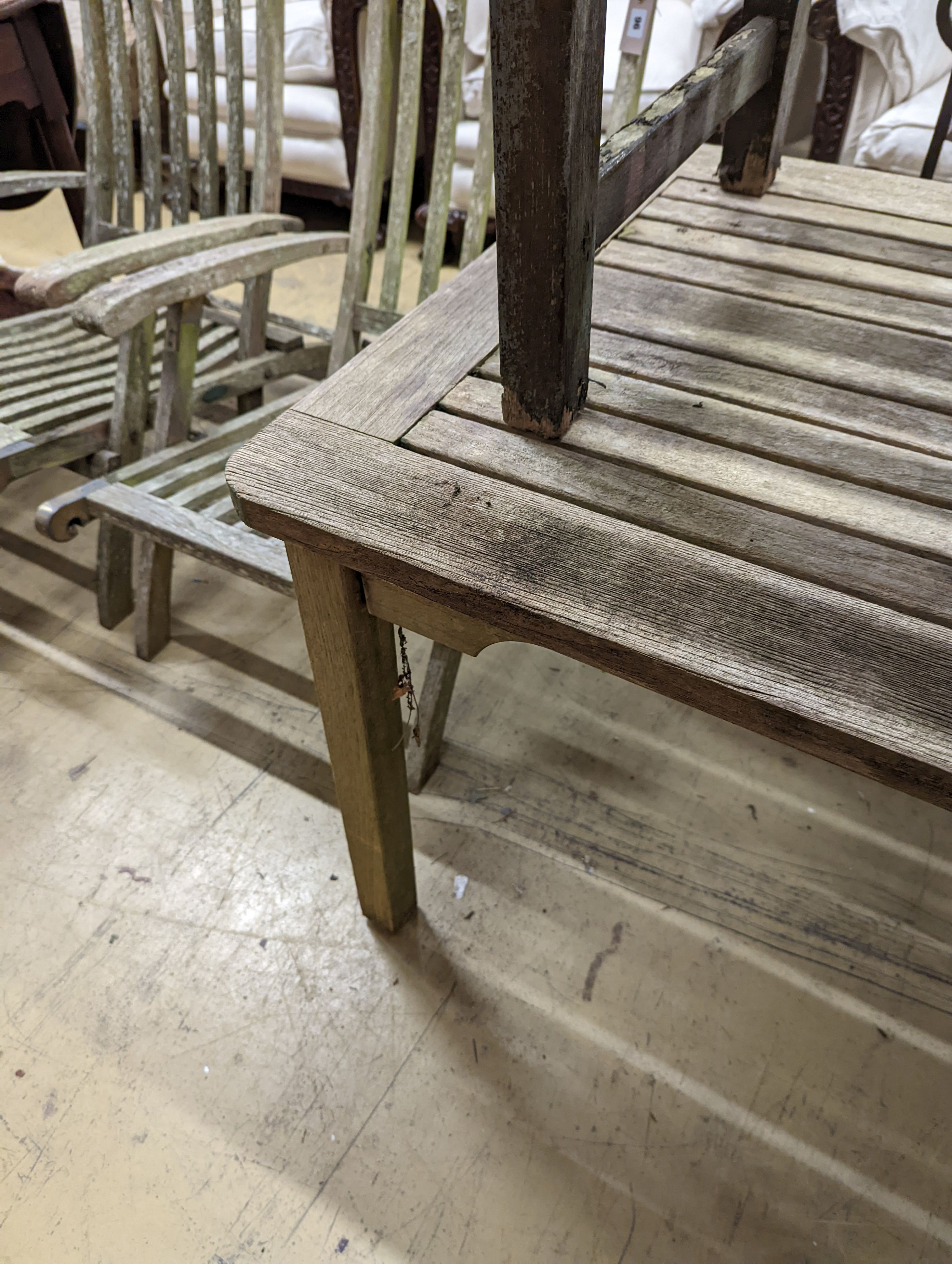 A weathered teak garden bench and rectangular table. Bench - W-122cm, D-54cm, H-83cm. Table - W-149cm, D-70cm, H-74cm.